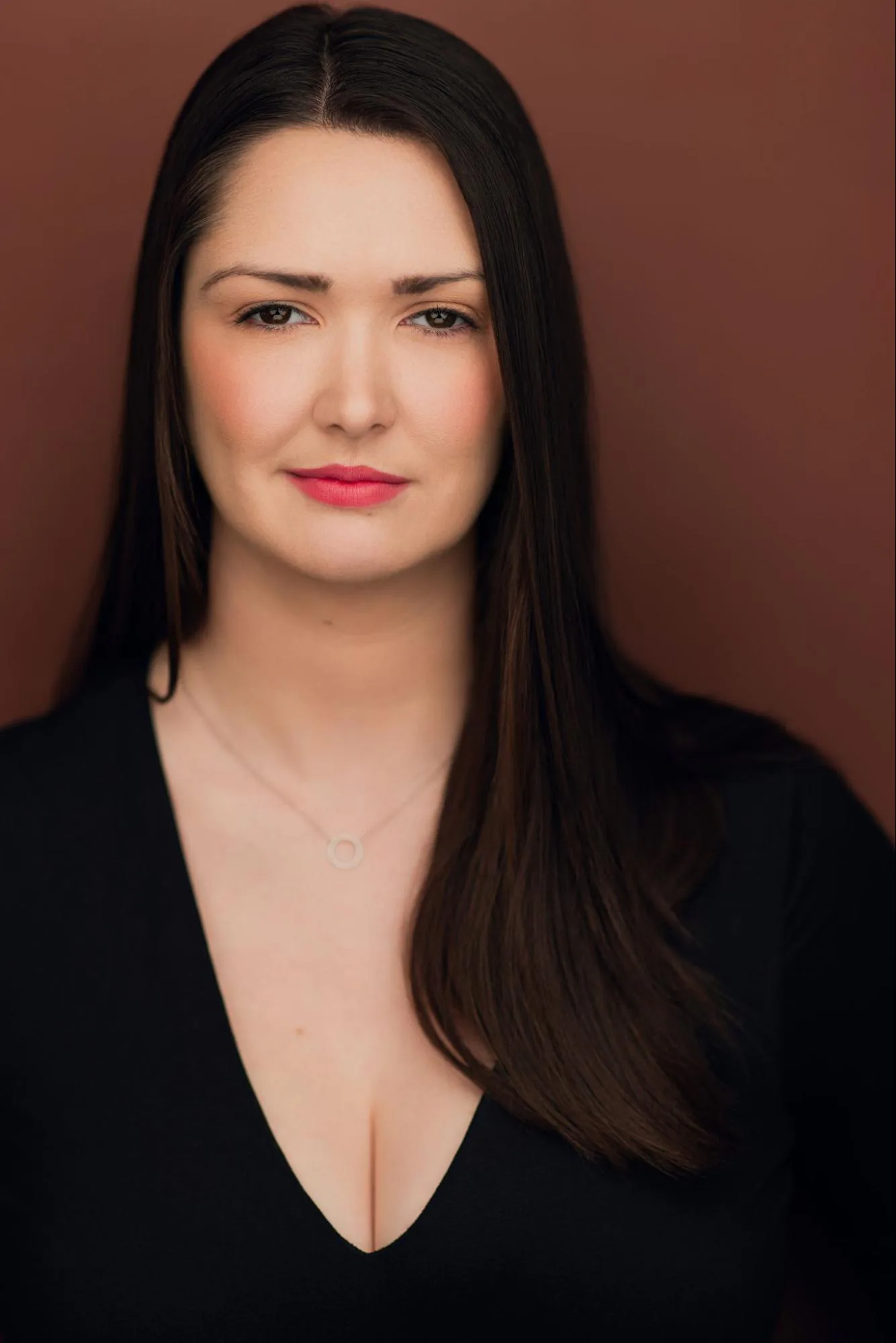 Veronica Murphy in black against a warm brown background