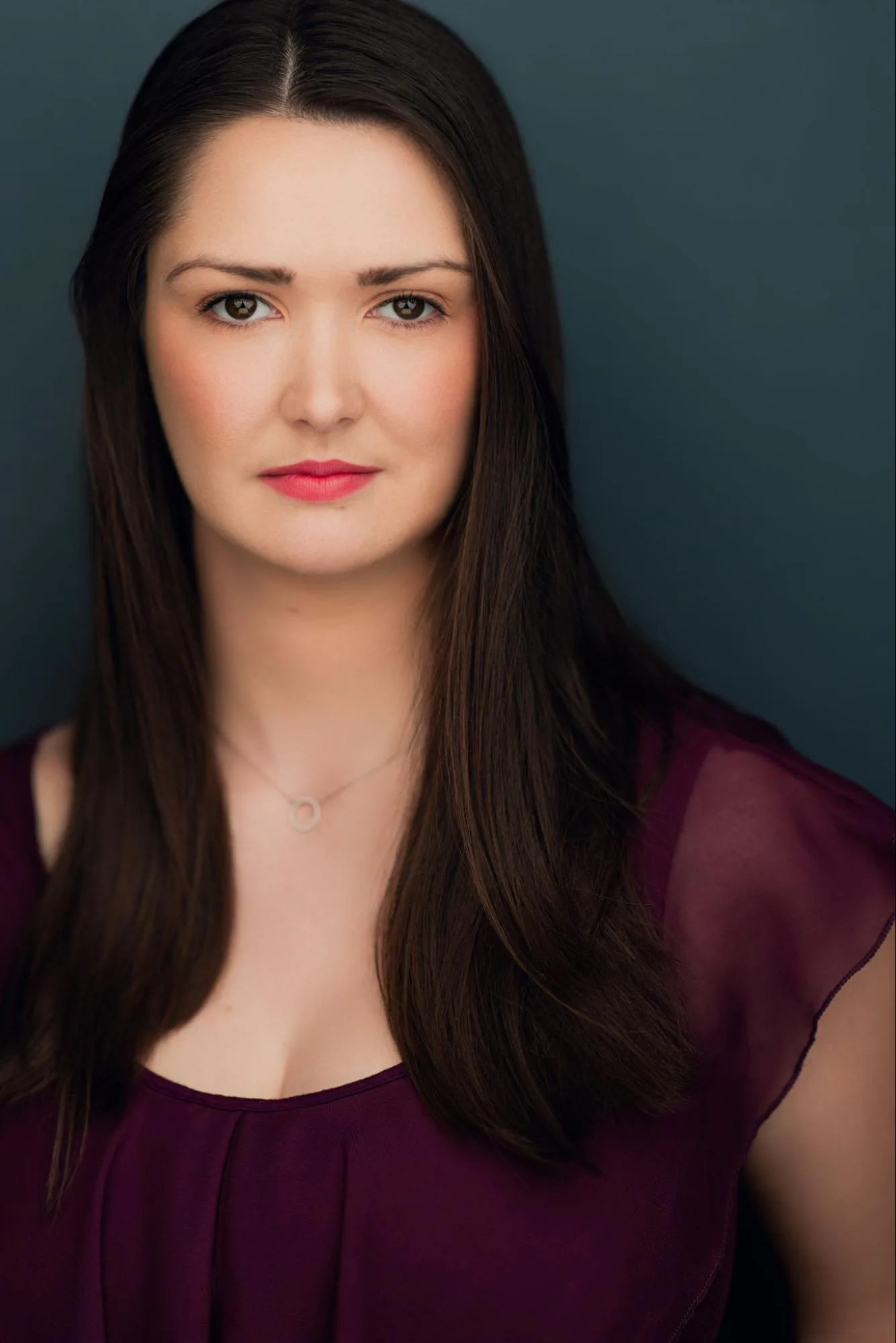 Veronica Murphy in a plum top against a blue background